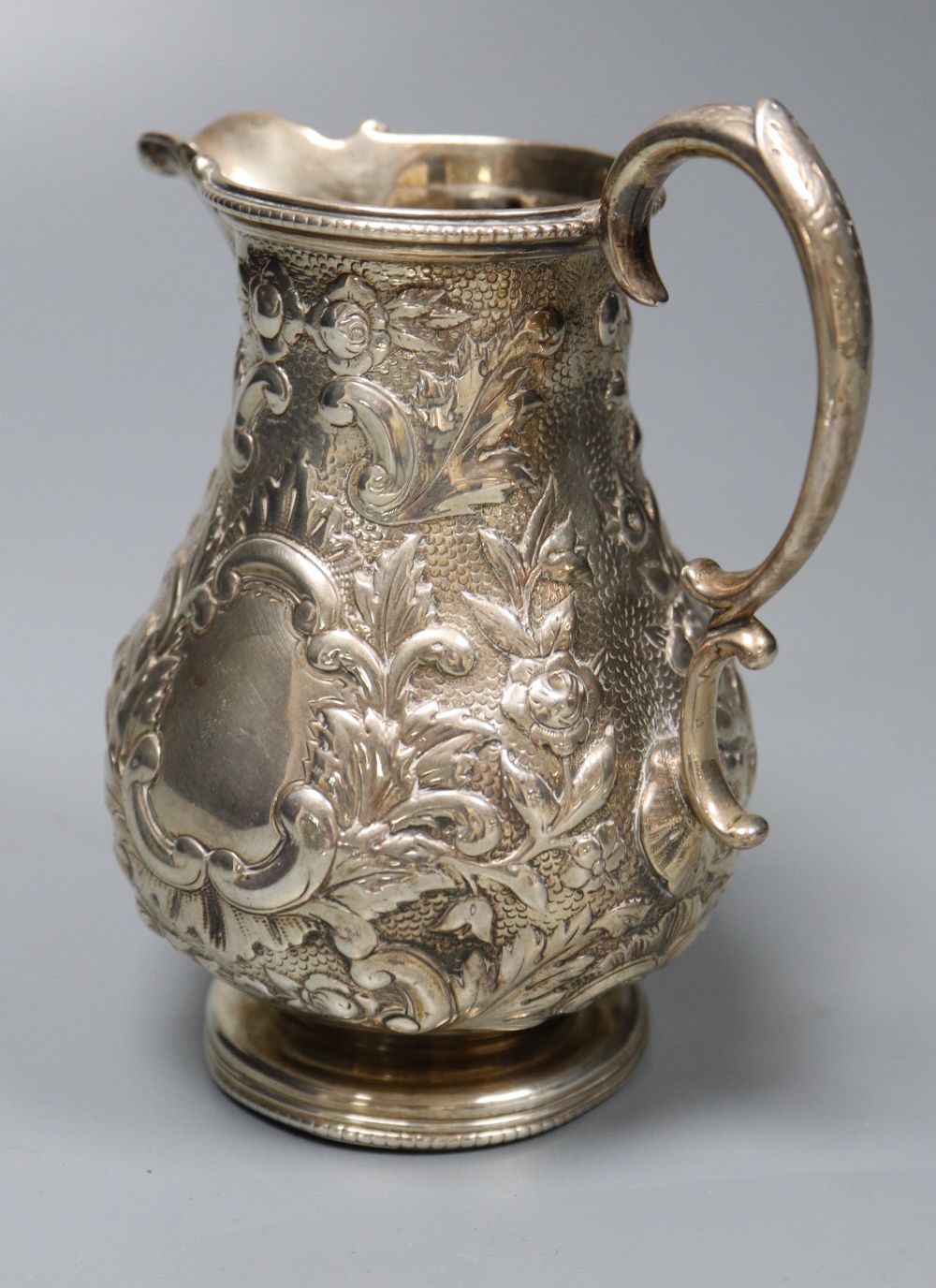 A Victorian embossed silver milk jug, Sheffield, 1860 and a silver salver, London, 1857, 27.5cm, 26oz.